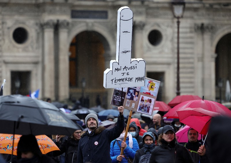 Demonstran memegang spanduk bertuliskan 