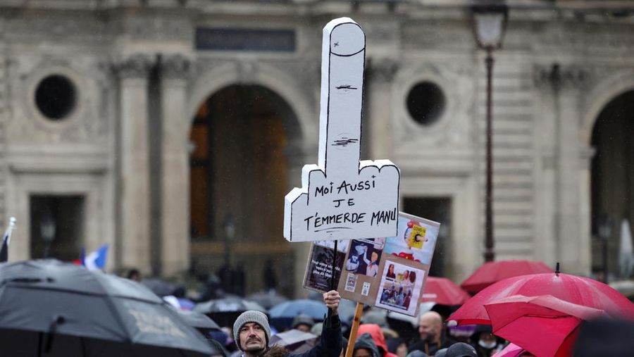 Demonstran memegang spanduk bertuliskan 