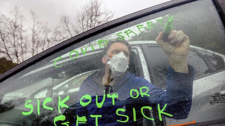 Demonstran memegang spanduk bertuliskan 