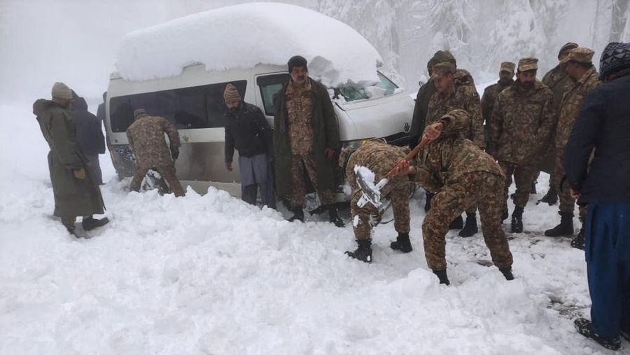 Kendaraan terjebak pohon tumbang di jalan bersalju Murree, timur laut Islamabad, Pakistan, Sabtu (8/1/2022). (via REUTERS/ISPR)