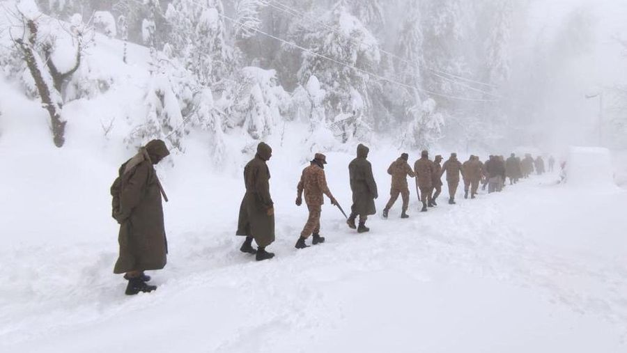 Kendaraan terjebak pohon tumbang di jalan bersalju Murree, timur laut Islamabad, Pakistan, Sabtu (8/1/2022). (via REUTERS/ISPR)