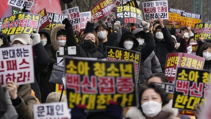 Seorang pengunjuk rasa mengangkat kartunya saat rapat umum menuntut pemerintah mencabut rencananya untuk memperluas program izin vaksin COVID-19, di dekat kompleks pemerintah di Seoul, Korea Selatan, Sabtu, 8 Januari 2022. (AP/Vadim Ghirda)