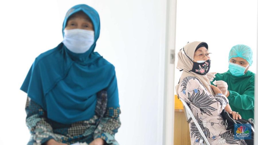 Tenaga kesehatan menyuntikkan vaksin COVID-19 dosis ketiga jenis Pfizer kepada warga saat vaksinasi booster Covid-19 di RSUI, Depok, Jawa Barat, Rabu (12/1/2022). (CNBC Indonesia/Muhammad Sabki)