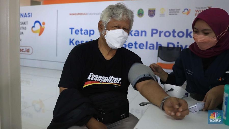 Tenaga kesehatan menyuntikkan vaksin COVID-19 dosis ketiga jenis Pfizer kepada warga saat vaksinasi booster Covid-19 di RSUI, Depok, Jawa Barat, Rabu (12/1/2022). (CNBC Indonesia/Muhammad Sabki)