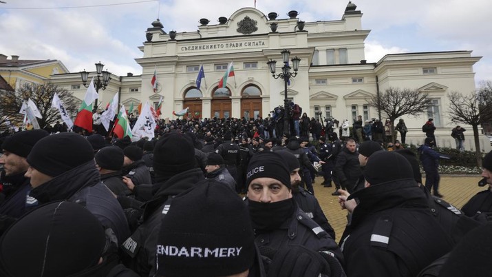 Para petugas polisi yang mencoba menjauhkan pengunjuk rasa dari gedung Parlemen Bulgaria di Sofia. (AP/Valentina Petrova)