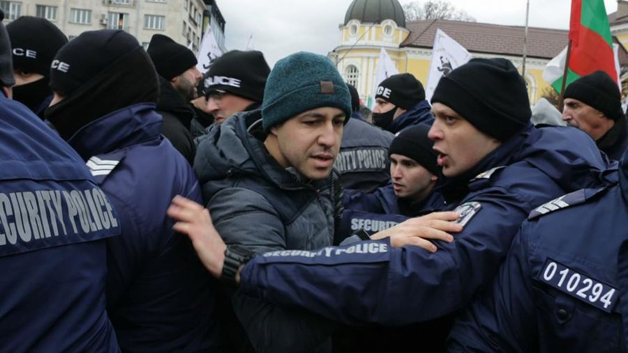 Para petugas polisi yang mencoba menjauhkan pengunjuk rasa dari gedung Parlemen Bulgaria di Sofia. (AP/Valentina Petrova)