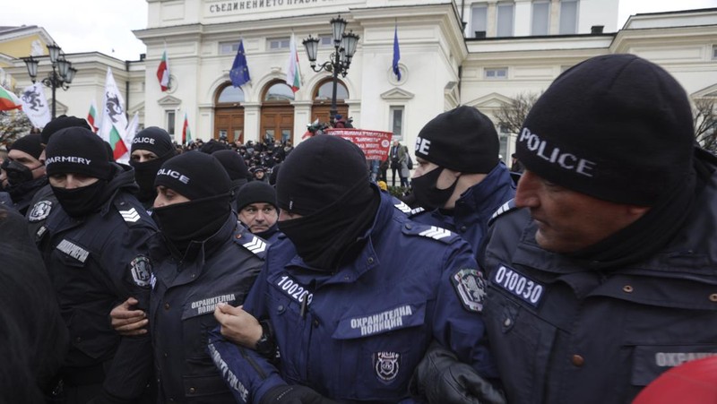 Para petugas polisi yang mencoba menjauhkan pengunjuk rasa dari gedung Parlemen Bulgaria di Sofia. (AP/Valentina Petrova)
