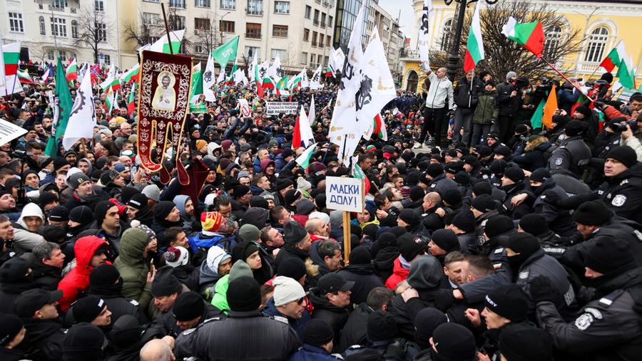 Para petugas polisi yang mencoba menjauhkan pengunjuk rasa dari gedung Parlemen Bulgaria di Sofia. (AP/Valentina Petrova)