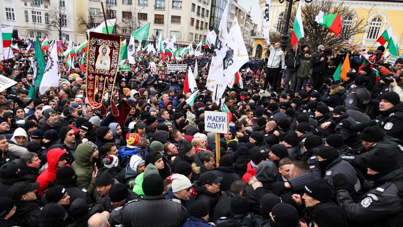 Para petugas polisi yang mencoba menjauhkan pengunjuk rasa dari gedung Parlemen Bulgaria di Sofia. (AP/Valentina Petrova)