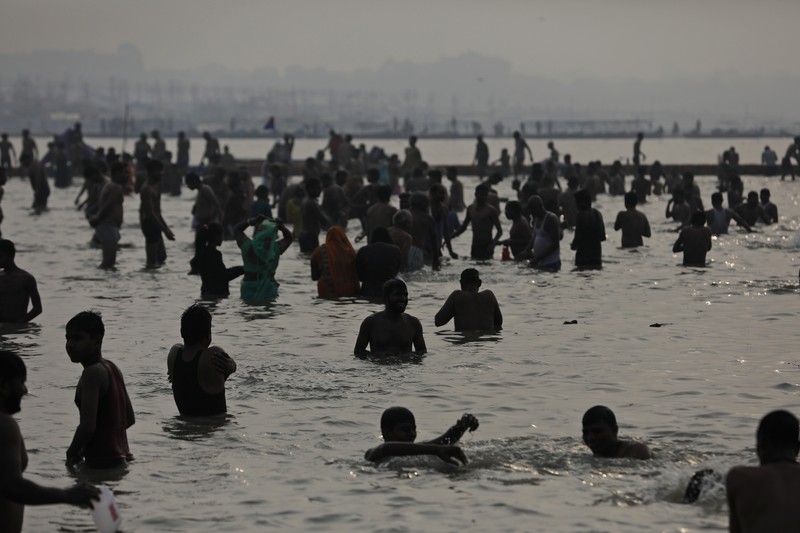 Hindu devotees crowd the Sangam, the confluence of three rivers — the Ganges, the Yamuna and the mythical Saraswati, to take a ritualistic bath during Makar Sankranti festival that falls during the annual traditional fair of Magh Mela festival, one of the most sacred pilgrimages in Hinduism, in Prayagraj, India. Friday, Jan. 14, 2022. Tens of thousands of devout Hindus, led by heads of monasteries and ash-smeared ascetics, took a holy dip into the frigid waters on Friday despite rising COVID-19 infections in the country. (AP Photo/Rajesh Kumar Singh)