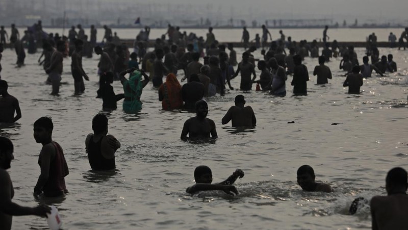 Hindu devotees crowd the Sangam, the confluence of three rivers — the Ganges, the Yamuna and the mythical Saraswati, to take a ritualistic bath during Makar Sankranti festival that falls during the annual traditional fair of Magh Mela festival, one of the most sacred pilgrimages in Hinduism, in Prayagraj, India. Friday, Jan. 14, 2022. Tens of thousands of devout Hindus, led by heads of monasteries and ash-smeared ascetics, took a holy dip into the frigid waters on Friday despite rising COVID-19 infections in the country. (AP Photo/Rajesh Kumar Singh)
