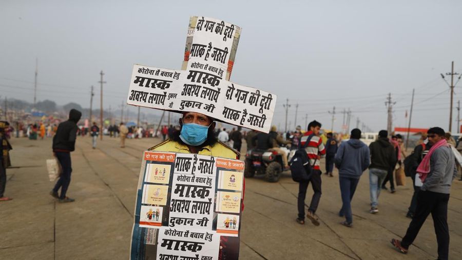 Hindu devotees crowd the Sangam, the confluence of three rivers — the Ganges, the Yamuna and the mythical Saraswati, to take a ritualistic bath during Makar Sankranti festival that falls during the annual traditional fair of Magh Mela festival, one of the most sacred pilgrimages in Hinduism, in Prayagraj, India. Friday, Jan. 14, 2022. Tens of thousands of devout Hindus, led by heads of monasteries and ash-smeared ascetics, took a holy dip into the frigid waters on Friday despite rising COVID-19 infections in the country. (AP Photo/Rajesh Kumar Singh)