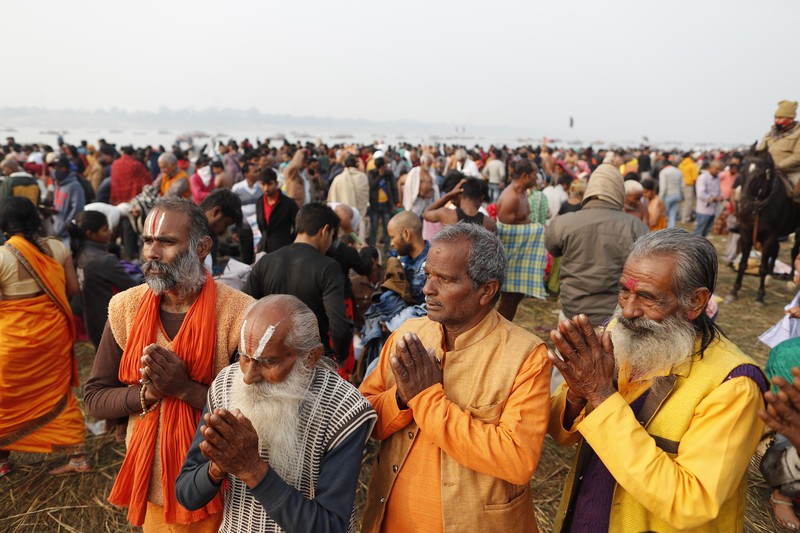 Hindu devotees crowd the Sangam, the confluence of three rivers — the Ganges, the Yamuna and the mythical Saraswati, to take a ritualistic bath during Makar Sankranti festival that falls during the annual traditional fair of Magh Mela festival, one of the most sacred pilgrimages in Hinduism, in Prayagraj, India. Friday, Jan. 14, 2022. Tens of thousands of devout Hindus, led by heads of monasteries and ash-smeared ascetics, took a holy dip into the frigid waters on Friday despite rising COVID-19 infections in the country. (AP Photo/Rajesh Kumar Singh)