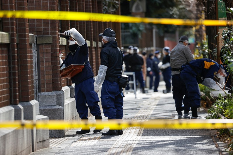 JAPAN-STABBING/ Police officers inspect at the site where a stabbing incident happened at an entrance gate of Tokyo University in Tokyo, Japan January 15, 2022. REUTERS/Issei Kato