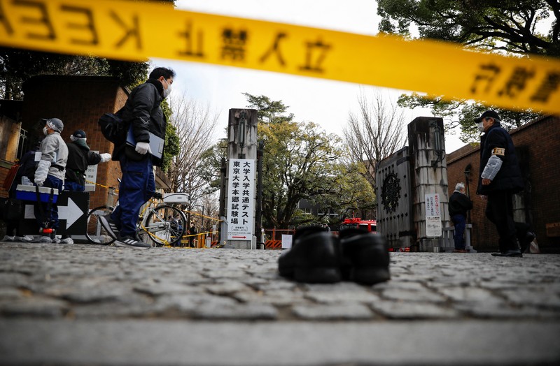 JAPAN-STABBING/ Police officers inspect at the site where a stabbing incident happened at an entrance gate of Tokyo University in Tokyo, Japan January 15, 2022. REUTERS/Issei Kato