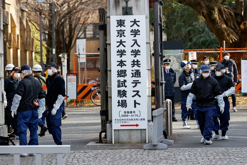JAPAN-STABBING/ Police officers inspect at the site where a stabbing incident happened at an entrance gate of Tokyo University in Tokyo, Japan January 15, 2022. REUTERS/Issei Kato