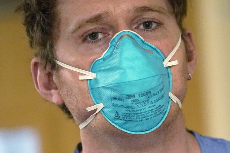 APTOPIX Virus Outbreak Washington Registered nurse Jessalynn Dest, left, removes protective equipment and washes her hands after leaving a COVID-19 patient's room as speech therapist Sam Gibbs puts on safety clothing while preparing to see a patient in the acute care unit of Harborview Medical Center, Friday, Jan. 14, 2022, in Seattle. Washington Gov. Jay Inslee is deploying 100 members of the state National Guard to hospitals across the state amid staff shortages due to an omicron-fueled spike in COVID-19 hospitalizations. Inslee announced Thursday that teams will be deployed to assist four overcrowded emergency departments at hospitals in Everett, Yakima, Wenatchee and Spokane, and that testing teams will be based at hospitals in Olympia, Richland, Seattle and Tacoma. (AP Photo/Elaine Thompson)