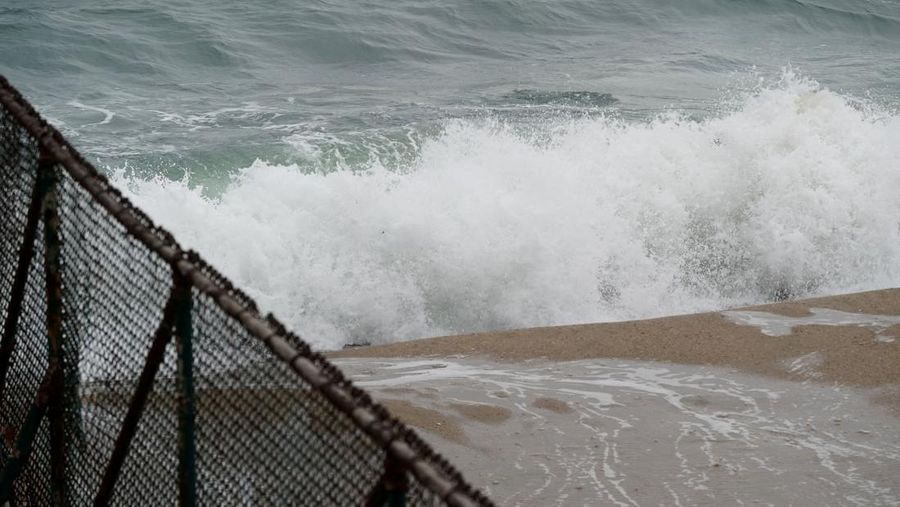 Ombak besar terlihat di pantai tertutup setelah peringatan tsunami dikeluarkan menyusul letusan gunung berapi bawah laut lebih dari 8500 km (sekitar 5300 mil) jauhnya di Seal Beach, California, AS, Sabtu (15/1/2022). (REUTERS/Bing Guan)