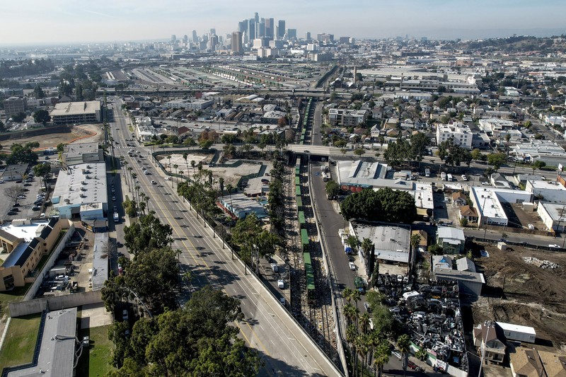 Pekerja kontraktor Adam Rodriguez (depan) dan Luis Rosas mengambil ban kendaraan dari kotak dan paket yang robek di sepanjang bagian rel kereta Union Pacific di pusat kota Los Angeles Jumat (14/1/2022).  Pencuri telah merampok kontainer kargo di atas kereta dekat pusat kota Los Angeles selama berbulan-bulan dan juga mereka meninggalkan ratusan kardus dan barang-barang yang menurut para pencuri tidak cukup berharga untuk diambil. (AP/Ringo H.W. Chiu)
