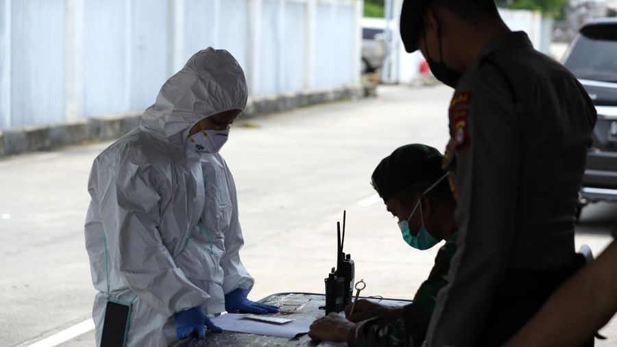 Petugas ambulans memberikan data pasien Covid-19  kepada petugas jaga di Wisma Atlet, Jakarta, Senin (17/1/2022). (CNBC Indonesia/Tri Susilo)