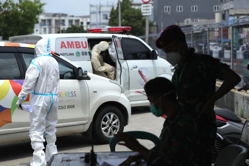 Petugas ambulans memberikan data pasien Covid-19  kepada petugas jaga di Wisma Atlet, Jakarta, Senin (17/1/2022). (CNBC Indonesia/Tri Susilo)