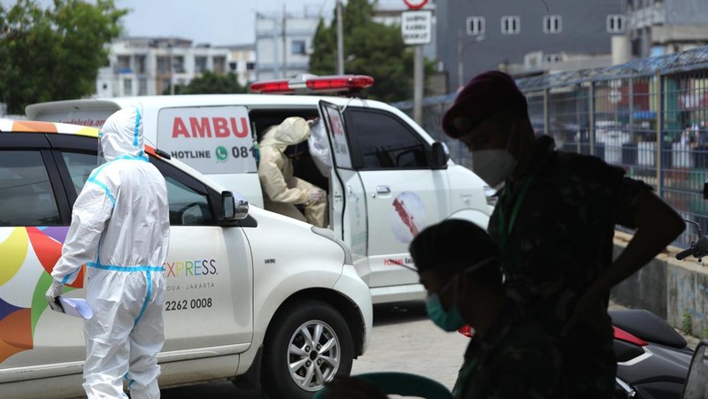 Petugas ambulans memberikan data pasien Covid-19  kepada petugas jaga di Wisma Atlet, Jakarta, Senin (17/1/2022). (CNBC Indonesia/Tri Susilo)