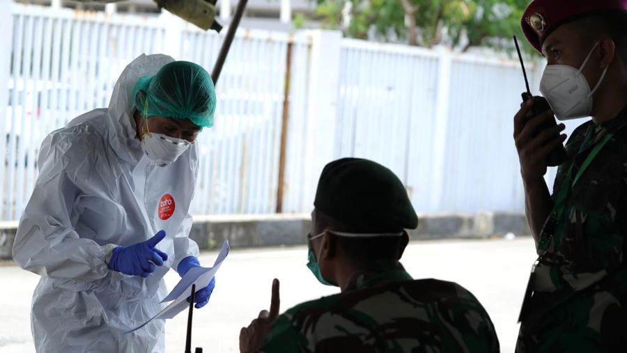 Petugas ambulans memberikan data pasien Covid-19  kepada petugas jaga di Wisma Atlet, Jakarta, Senin (17/1/2022). (CNBC Indonesia/Tri Susilo)