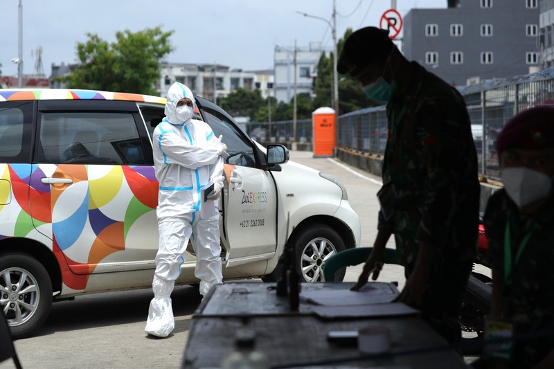 Petugas ambulans memberikan data pasien Covid-19  kepada petugas jaga di Wisma Atlet, Jakarta, Senin (17/1/2022). (CNBC Indonesia/Tri Susilo)