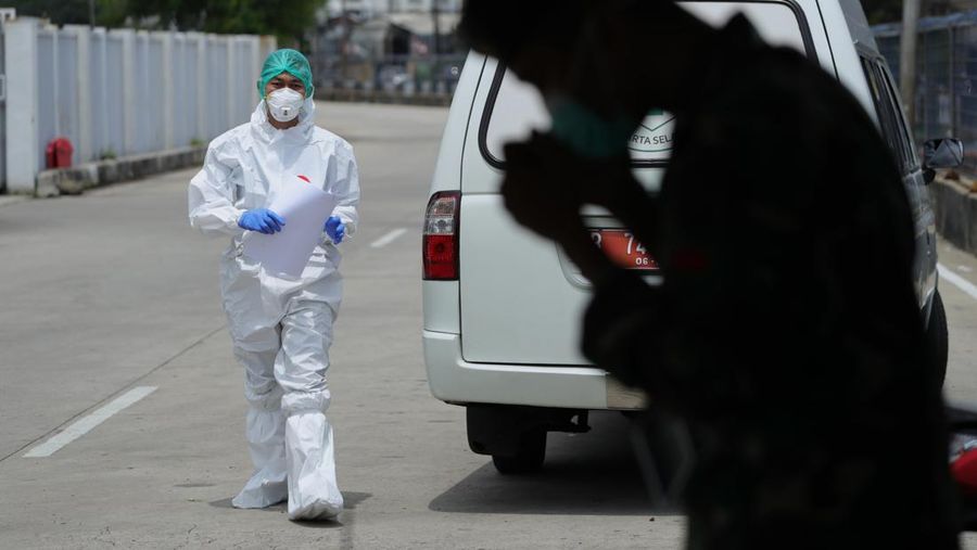 Petugas ambulans memberikan data pasien Covid-19  kepada petugas jaga di Wisma Atlet, Jakarta, Senin (17/1/2022). (CNBC Indonesia/Tri Susilo)