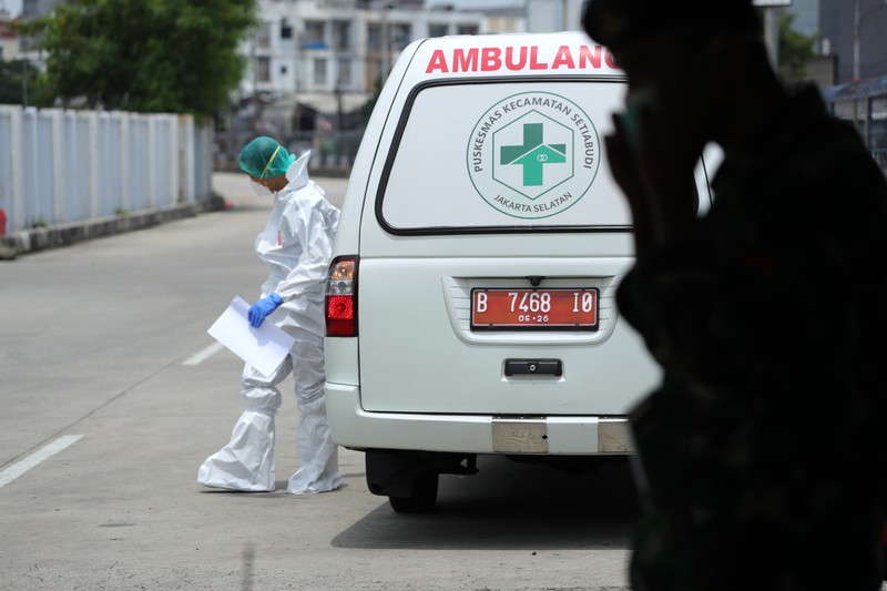 Petugas ambulans memberikan data pasien Covid-19  kepada petugas jaga di Wisma Atlet, Jakarta, Senin (17/1/2022). (CNBC Indonesia/Tri Susilo)