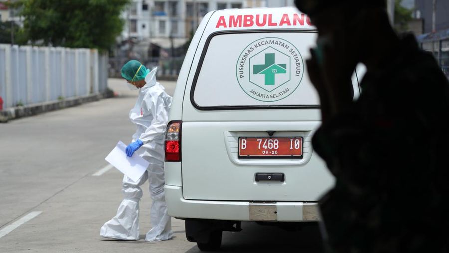 Petugas ambulans memberikan data pasien Covid-19  kepada petugas jaga di Wisma Atlet, Jakarta, Senin (17/1/2022). (CNBC Indonesia/Tri Susilo)