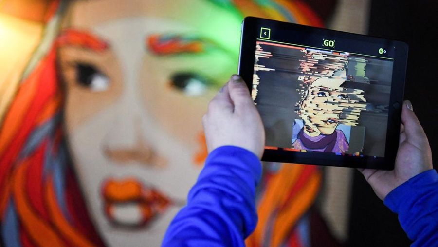 FILE PHOTO: Hands holding a tablet computer are pictured during a tour through the urban NFT LAB called 