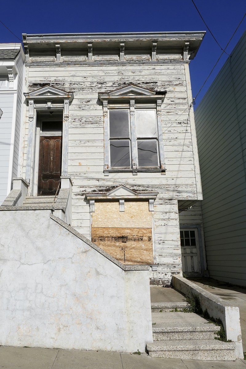 A pedestrian walks a dog past a recently sold Victorian home in San Francisco, Friday, Jan. 14, 2022. The decaying, 122-year-old Victorian marketed as 