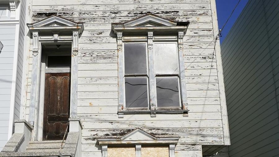 A pedestrian walks a dog past a recently sold Victorian home in San Francisco, Friday, Jan. 14, 2022. The decaying, 122-year-old Victorian marketed as 