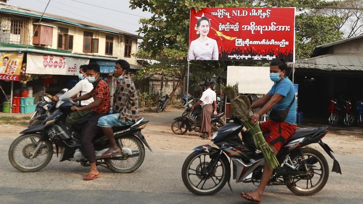 Myanmar Election Bikers drive past a signboard welcoming the new government of Myanmar leader Aung San Suu Kyi in Yangon, Myanmar on Friday, Jan. 29, 2021. Myanmar's election commission rejected allegations by the military that fraud played a significant role in determining the outcome of November's elections, which delivered a landslide victory to Aung San Suu Kyi's ruling party.(AP Photo/Thein Zaw)