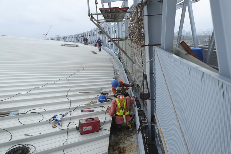 Pekerja melakukan perakitan rangka atap pinggir sky viewing deck di Stadion Internasional Stadium (JIS), Rabu (19/1/2022).   (CNBC Indonesia/Tri Susilo)