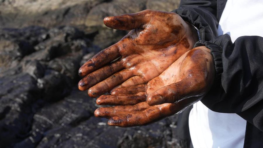 Oil floats in the water off Cavero beach in Ventanilla, Callao, Peru, Tuesday, Jan. 18, 2022, after high waves attributed to the eruption of an undersea volcano in Tonga caused an oil spill. The Peruvian Civil Defense Institute said in a press release that a ship was loading oil into La Pampilla refinery on the Pacific coast on Sunday when strong waves moved the boat and caused the spill. (AP Photo/Martin Mejia)