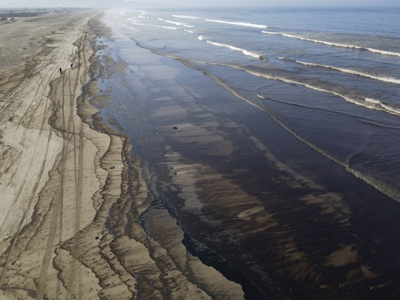 Peru Oil Spill Tonga Oil floats in the water off Cavero beach in Ventanilla, Callao, Peru, Tuesday, Jan. 18, 2022, after high waves attributed to the eruption of an undersea volcano in Tonga caused an oil spill. The Peruvian Civil Defense Institute said in a press release that a ship was loading oil into La Pampilla refinery on the Pacific coast on Sunday when strong waves moved the boat and caused the spill. (AP Photo/Martin Mejia)