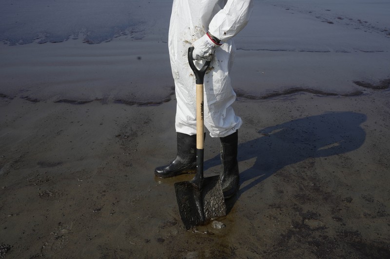 Oil floats in the water off Cavero beach in Ventanilla, Callao, Peru, Tuesday, Jan. 18, 2022, after high waves attributed to the eruption of an undersea volcano in Tonga caused an oil spill. The Peruvian Civil Defense Institute said in a press release that a ship was loading oil into La Pampilla refinery on the Pacific coast on Sunday when strong waves moved the boat and caused the spill. (AP Photo/Martin Mejia)