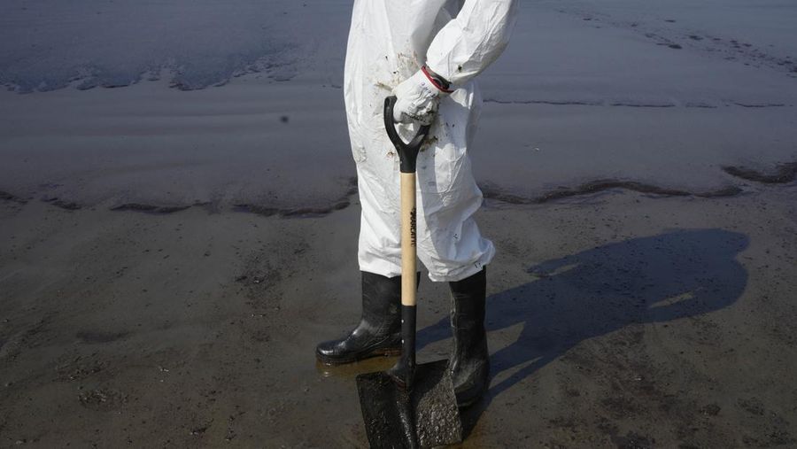 Oil floats in the water off Cavero beach in Ventanilla, Callao, Peru, Tuesday, Jan. 18, 2022, after high waves attributed to the eruption of an undersea volcano in Tonga caused an oil spill. The Peruvian Civil Defense Institute said in a press release that a ship was loading oil into La Pampilla refinery on the Pacific coast on Sunday when strong waves moved the boat and caused the spill. (AP Photo/Martin Mejia)