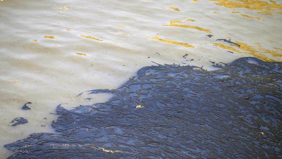 Oil floats in the water off Cavero beach in Ventanilla, Callao, Peru, Tuesday, Jan. 18, 2022, after high waves attributed to the eruption of an undersea volcano in Tonga caused an oil spill. The Peruvian Civil Defense Institute said in a press release that a ship was loading oil into La Pampilla refinery on the Pacific coast on Sunday when strong waves moved the boat and caused the spill. (AP Photo/Martin Mejia)