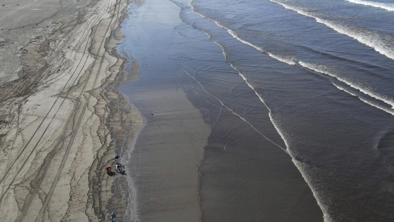 Oil floats in the water off Cavero beach in Ventanilla, Callao, Peru, Tuesday, Jan. 18, 2022, after high waves attributed to the eruption of an undersea volcano in Tonga caused an oil spill. The Peruvian Civil Defense Institute said in a press release that a ship was loading oil into La Pampilla refinery on the Pacific coast on Sunday when strong waves moved the boat and caused the spill. (AP Photo/Martin Mejia)