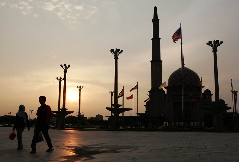 A Muslim couple walks past the Putrajaya Mosque after buying foods preparing for 1st day of Ramadan in Putrajaya, Malaysia, Sunday, Sept. 24, 2006. Muslims in Malaysia began preparations for Ramadan after religious officials confirmed the fasting month would start over the weekend. (AP Photo/Andy Wong)