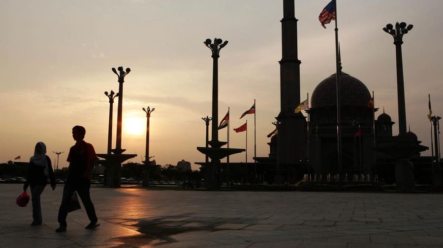 A Muslim couple walks past the Putrajaya Mosque after buying foods preparing for 1st day of Ramadan in Putrajaya, Malaysia, Sunday, Sept. 24, 2006. Muslims in Malaysia began preparations for Ramadan after religious officials confirmed the fasting month would start over the weekend. (AP Photo/Andy Wong)
