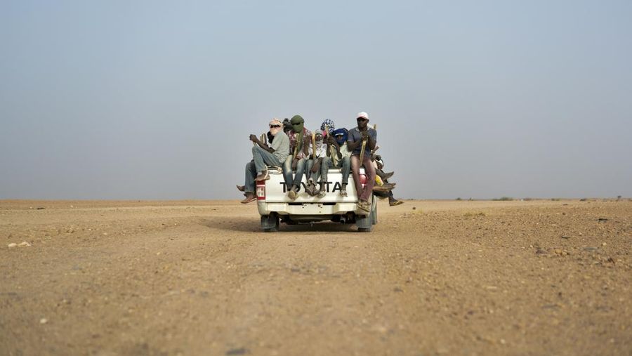FILE - In this Monday, June 4, 2018 file photo, Nigeriens and third-country migrants head towards Libya from Agadez, Niger. Algeria’s deadly expulsions of migrants into the Sahara Desert have nearly ground to a halt after widespread condemnation and the abrupt firing of two of its top security officials. Officials with the UN’s International Organization for Migration said the expulsions to the desert border Algeria shares with Niger and Mali had all but ended since The Associated Press reported more than 13,000 people had been dropped there since May 2017, including women and children.(AP Photo/Jerome Delay, File)
