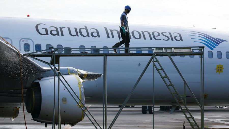 A worker walks on a crane as a Garuda Indonesia's aircraft is parked at the Garuda Maintenance Facility (GMF) AeroAsia, at Soekarno-Hatta International airport near Jakarta, Indonesia, January 21, 2022. REUTERS/Willy Kurniawan
