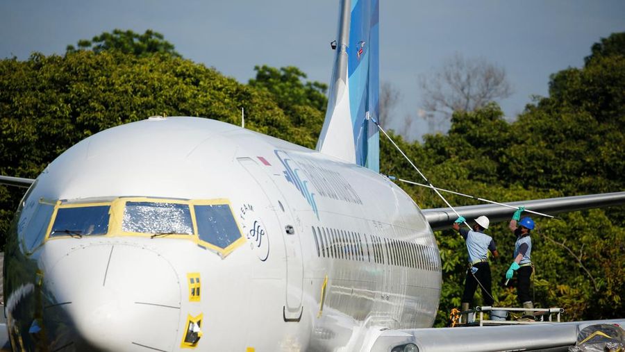 Workers clean a Garuda Indonesia's Boeing 737-800 NG aeroplane at the Garuda Maintenance Facility (GMF) AeroAsia, at Soekarno-Hatta International airport near Jakarta, Indonesia, January 21, 2022. REUTERS/Willy Kurniawan