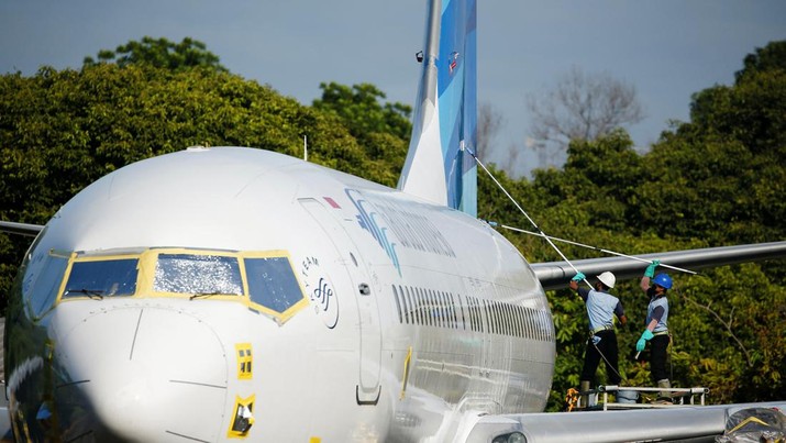 GARUDA INDONESIA-DEBT/ Workers clean a Garuda Indonesia's Boeing 737-800 NG aeroplane at the Garuda Maintenance Facility (GMF) AeroAsia, at Soekarno-Hatta International airport near Jakarta, Indonesia, January 21, 2022. REUTERS/Willy Kurniawan