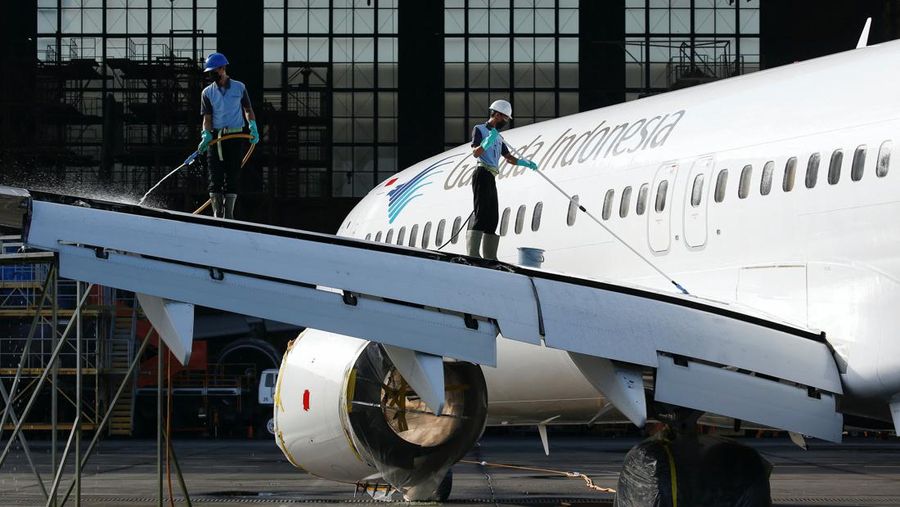 Workers clean a Garuda Indonesia's Boeing 737-800 NG aeroplane at the Garuda Maintenance Facility (GMF) AeroAsia, at Soekarno-Hatta International airport near Jakarta, Indonesia, January 21, 2022. REUTERS/Willy Kurniawan