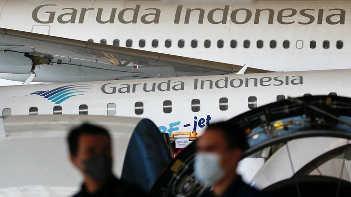 Technicians walk as Garuda Indonesia's aircraft are parked for maintenances at the Garuda Maintenance Facility (GMF) AeroAsia, at Soekarno-Hatta International airport near Jakarta, Indonesia, January 21, 2022. REUTERS/Willy Kurniawan